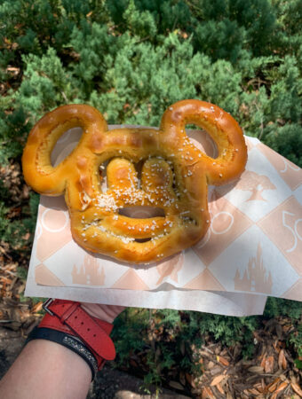 woman holds a Disney World Mickey Mouse pretzel at Hollywood Studios