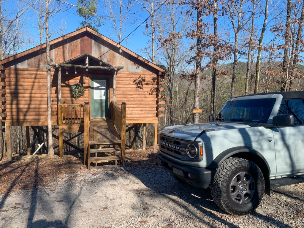 a grey Ford Bronco in front of a Hot Springs treehouse cabins at Starlight Haven