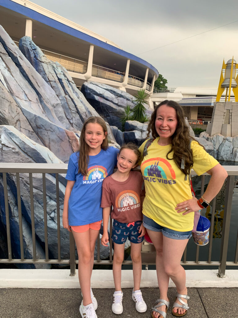 Arkansas lifestyle blogger, Amy, and two daughters pose in front of Disney attraction