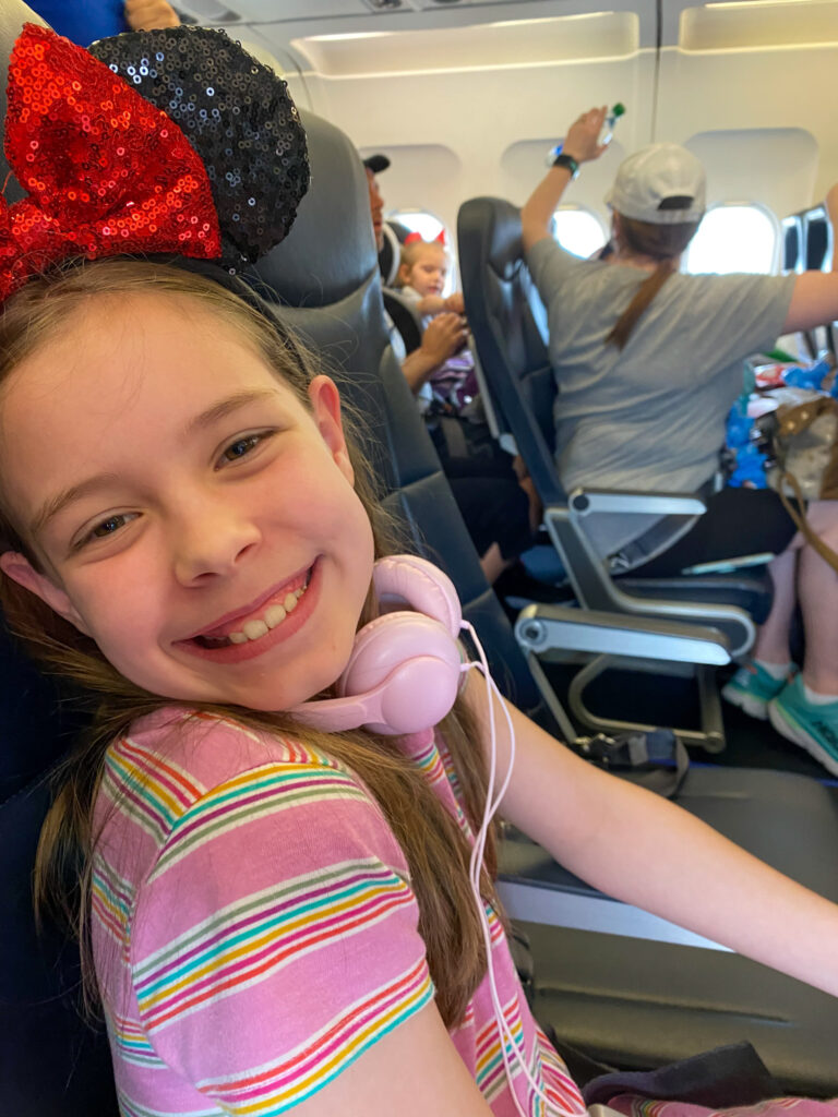 little girl on Frontier Airlines flight from Little Rock to Orlando while wearing mouse ears and headphones