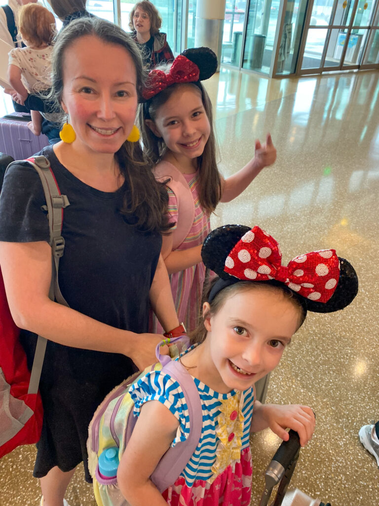 Arkansas lifestyle blogger, Amy Gramlich, with daughters wearing Minnie Mouse ears in the Little Rock airport