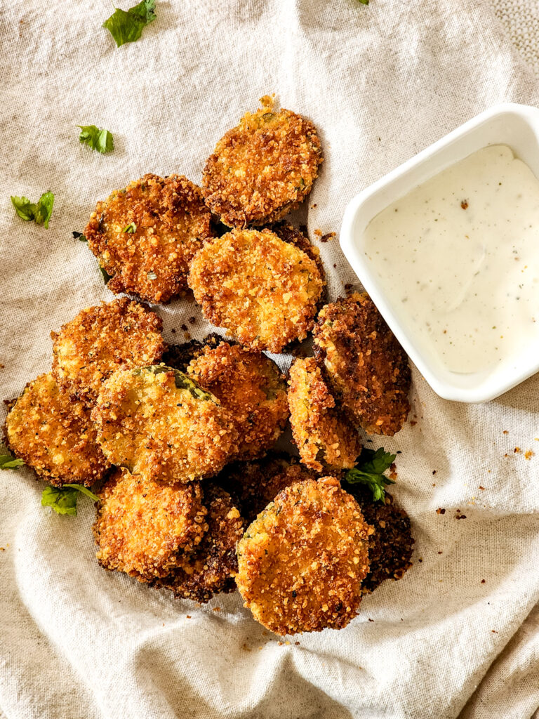 parmesan fried pickles on tablecloth with ranch dressing to side