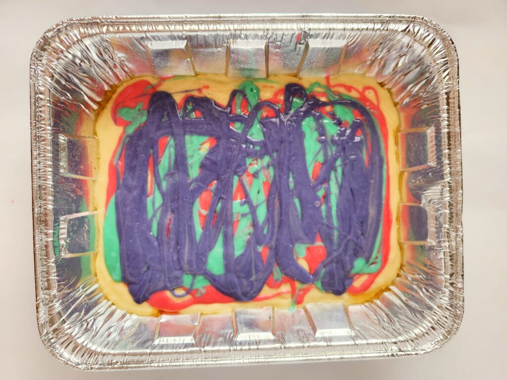 rainbow swirl cake with food coloring batter in tin 9x13 pan