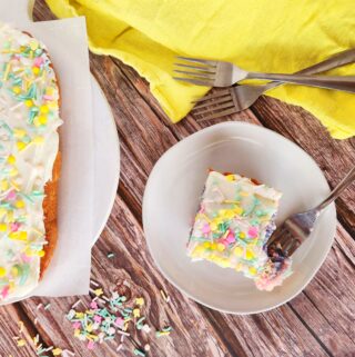 rainbow cake with food coloring and sprinkles beside yellow napkin