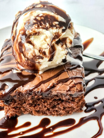 copycat Cracker Barrel Coca Cola cake with ice cream and syrup on a white plate