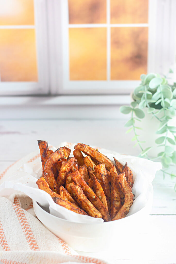 bowl of home fries in air fryer with plant in back