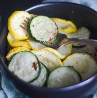bowl of air fryer zucchini and squash with a fork in the middle