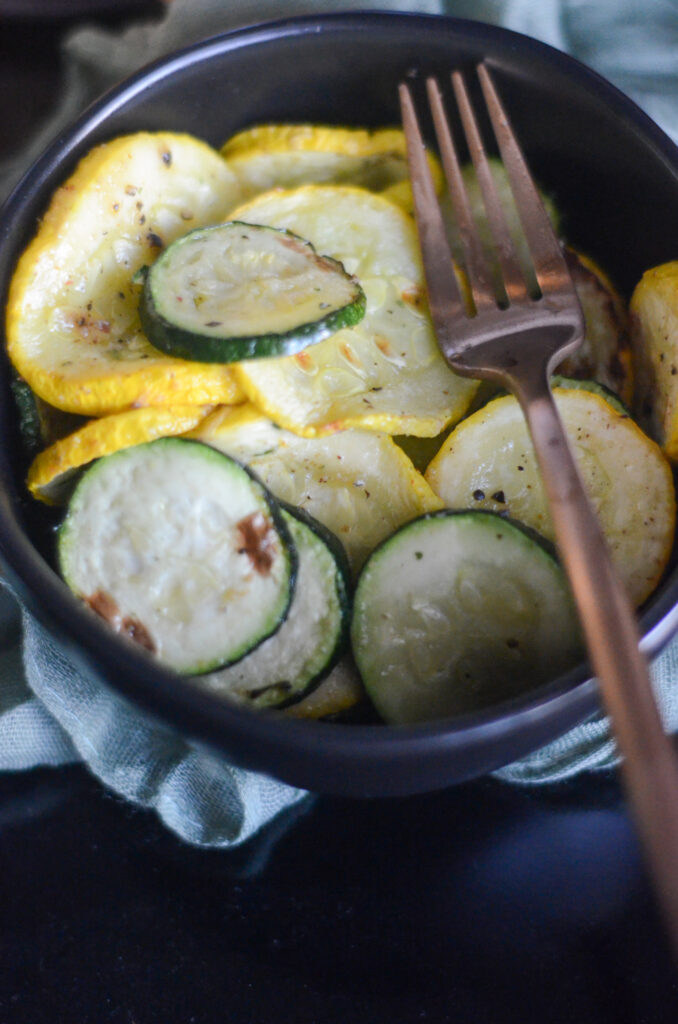 bowl of air fryer squash and zucchini in black bowl with fork