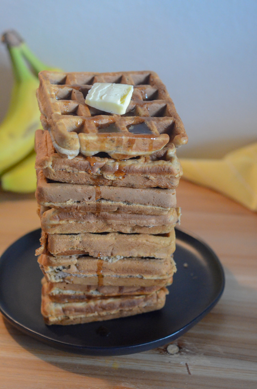 tall stack of banana waffles with walnuts
