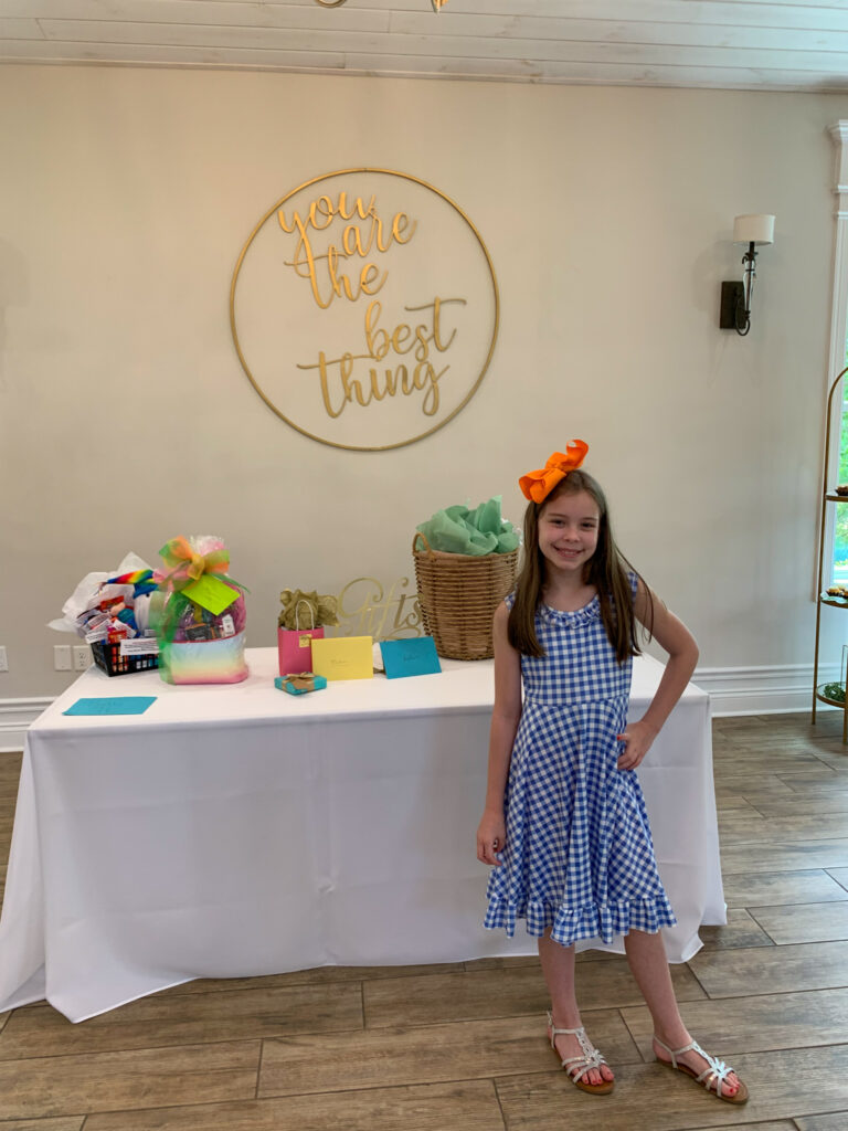 Arkansas tween blogger, Harper, helps guests with gifts at a gift table