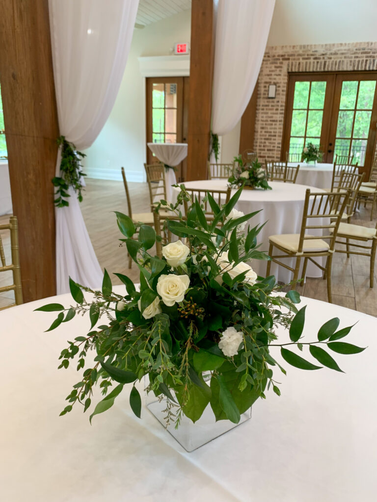 greenery with white roses on tables at White Oak Venue in Ruston, Louisiana for a graduation tea party