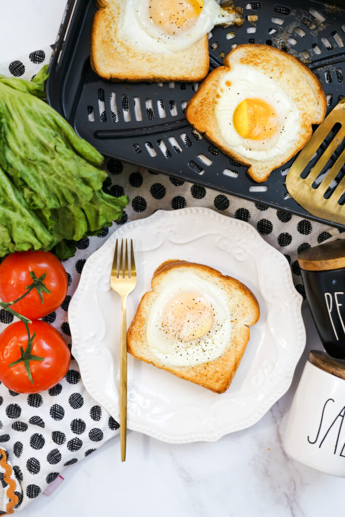 air fryer egg toast on white plate with more TikTok toast in tray at back