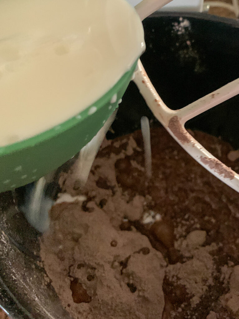 milk pouring into mixture in mixing bowl