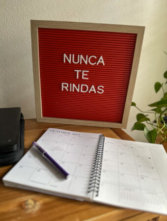 red letter board with inspirational quotes in Spanish and paper calendar in front of it