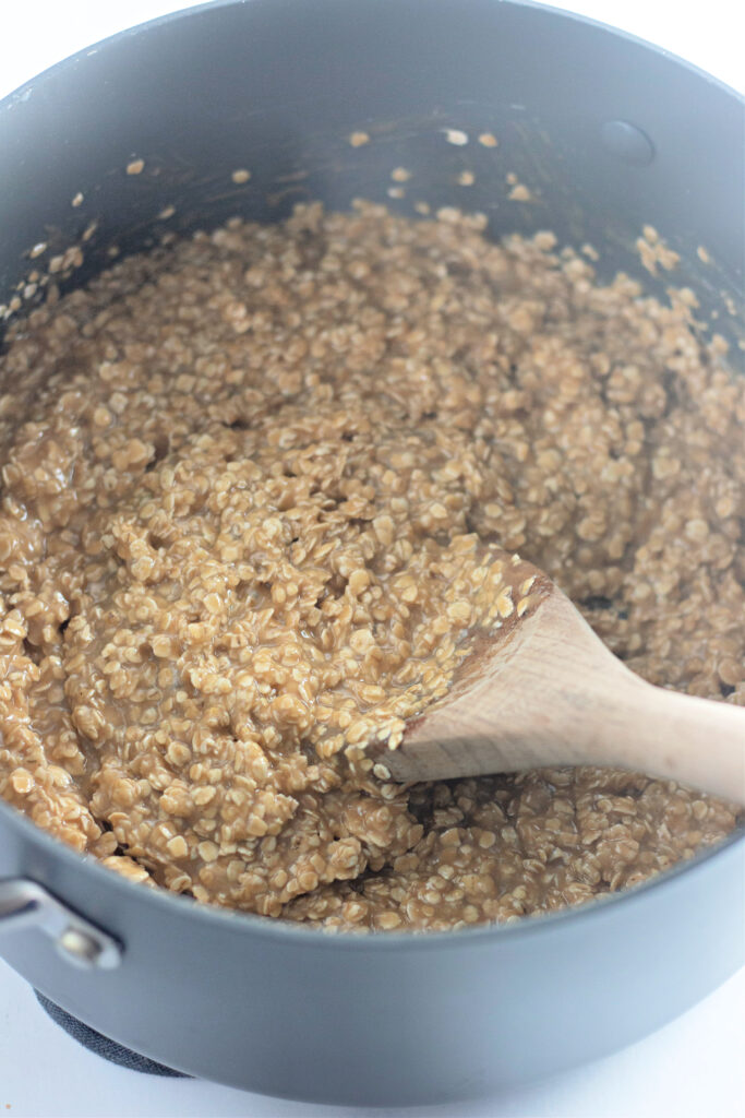 black pot with oatmeal mixture and wooden spoon