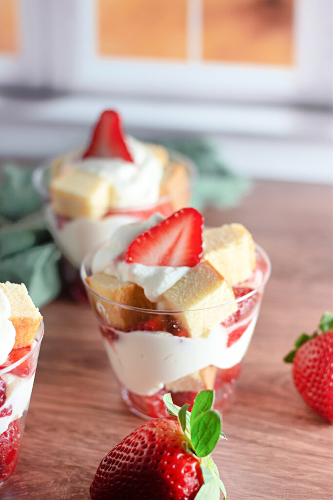 strawberry shortcake cups on wooden table with strawberries