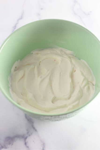 bowl of homemade whipped cream in green bowl