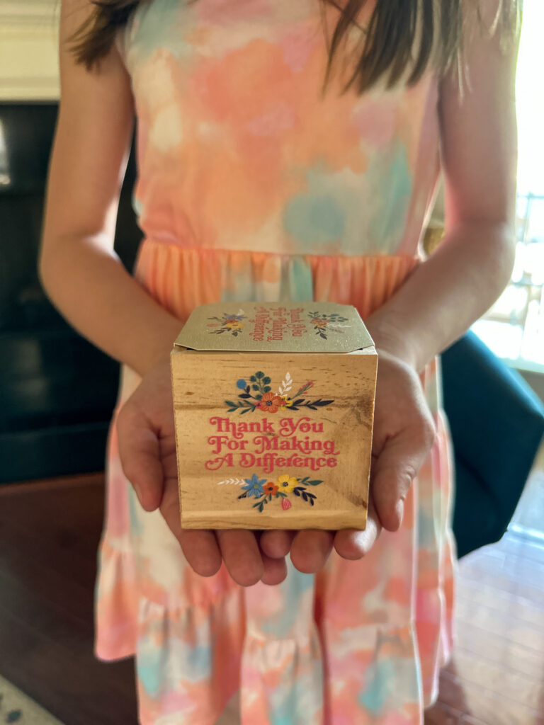 girl holds teacher appreciation wooden planter with seeds