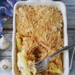 bacon alfredo pasta bake in a white dish with a fork on top