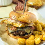 bagel burger for breakfast on plate with knife inserted