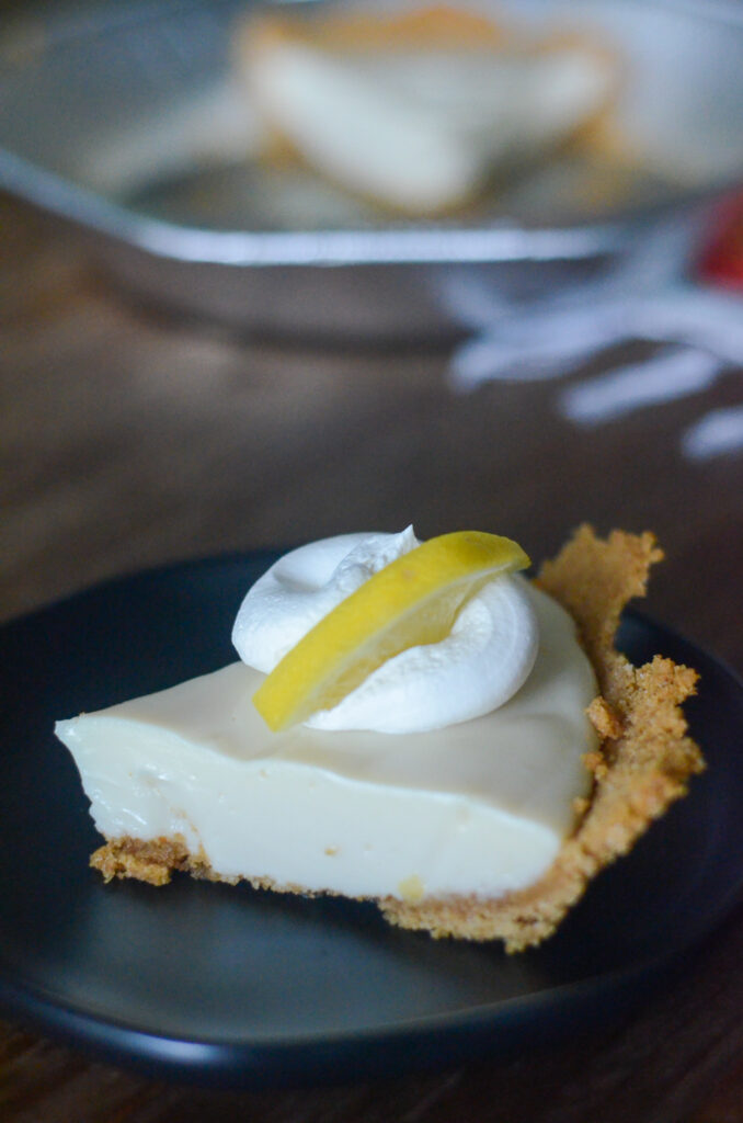 lemon cream pie with whipped cream and lemon garnish on top