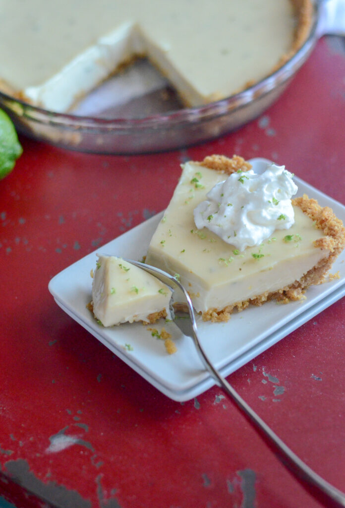fork cutting off end of sour cream key lime pie with condensed milk