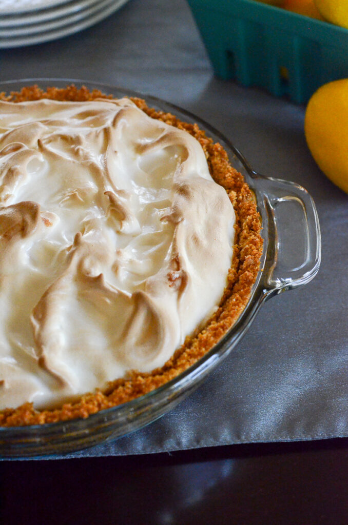 top down shot of an ice box lemon pie with marshmallow topping and lemons in back
