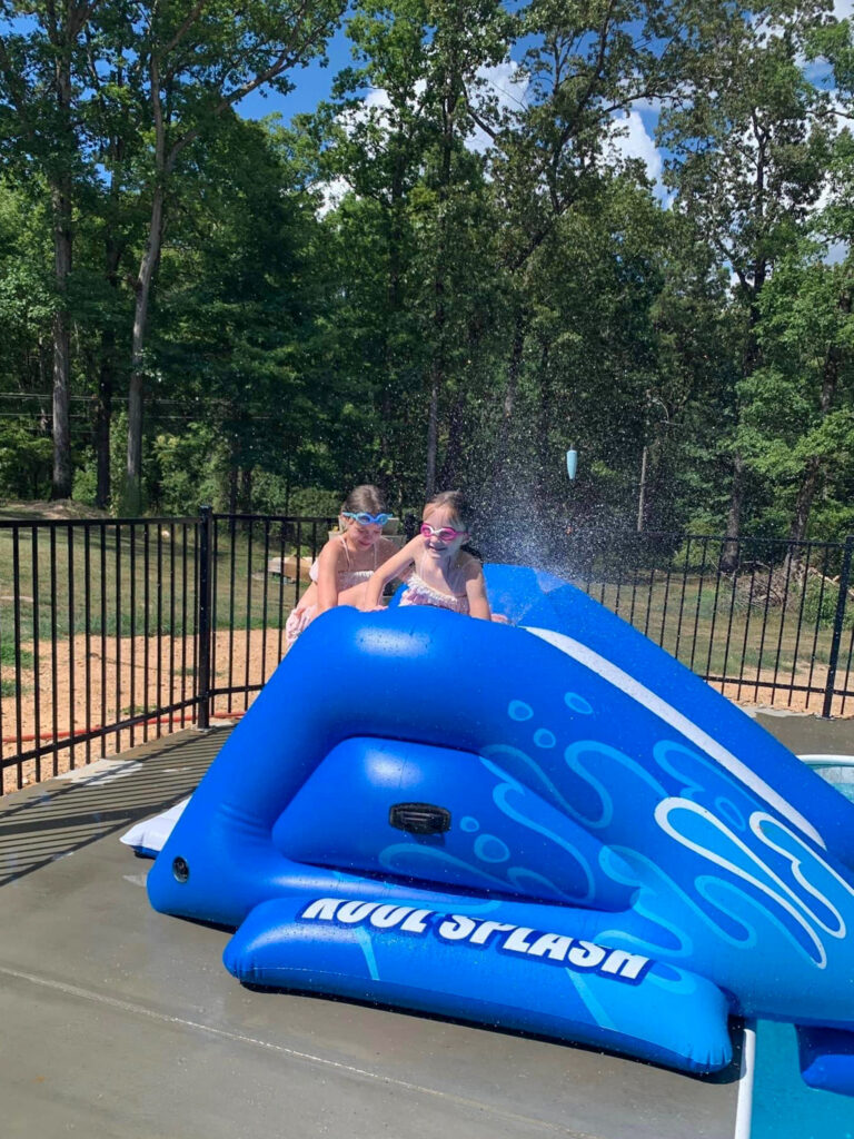 two girls preparing to slide down an Intex Kool Splash slide into a pool 