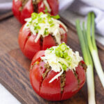 stuffed taco tomatoes on a dark wooden board