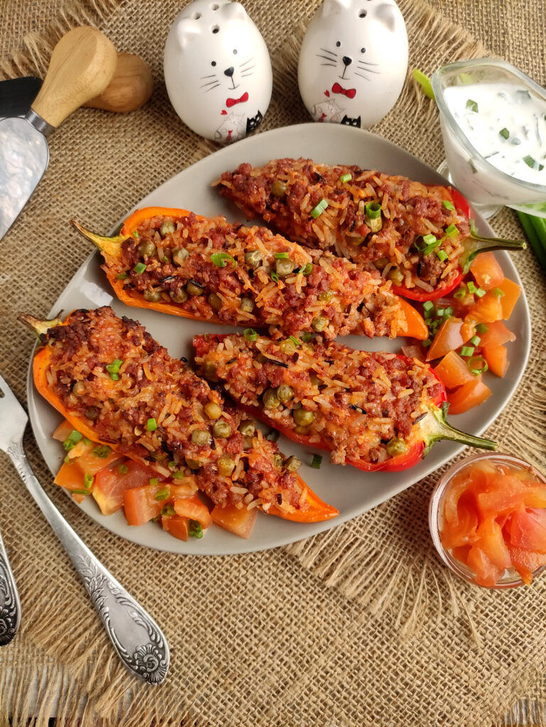 taco stuffed peppers on white plate with cat salt and pepper shakers in back