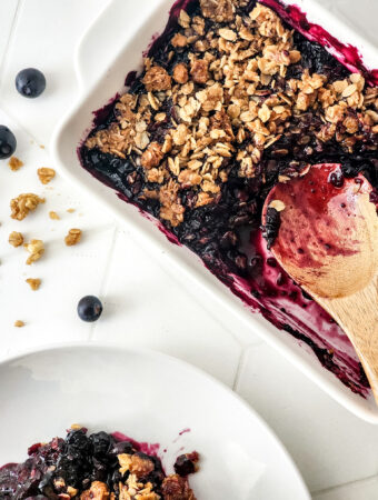 blueberry crisp with granola in white baking tray