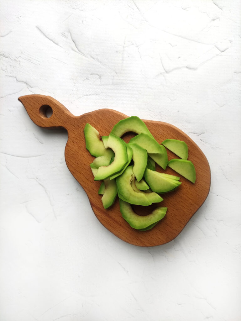 sliced avocados on a wood board