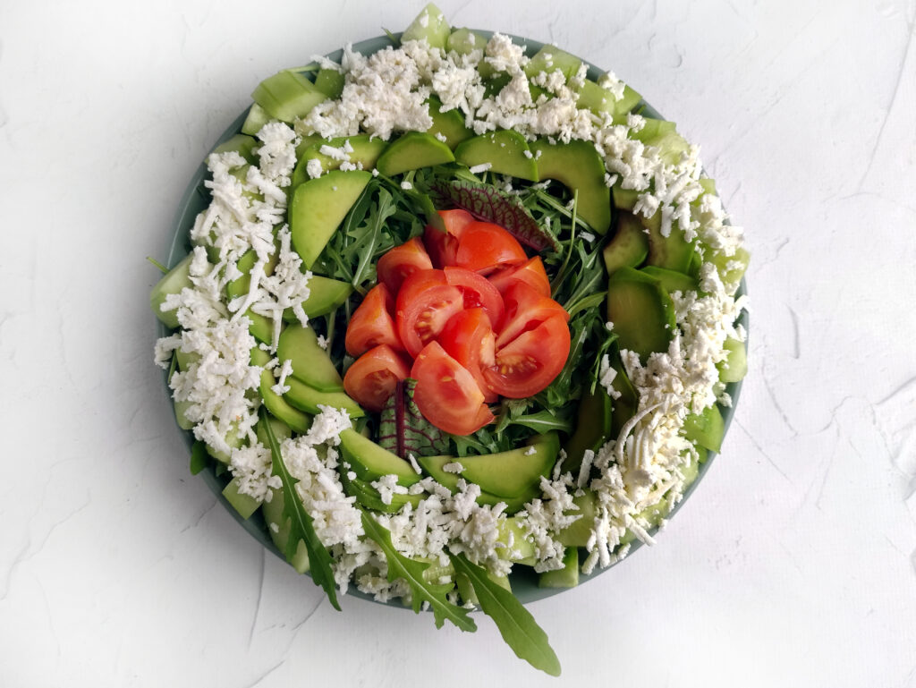 layers of a spinach arugula salad on plate