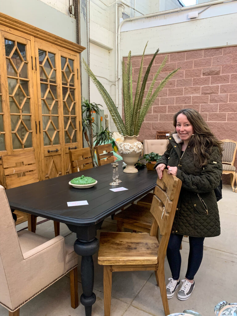 Arkansas lifestyle blogger, Amy, stands by gorgeous table and chairs at Bella Rustina Modern Vintage Market in Little Rock, Arkansas