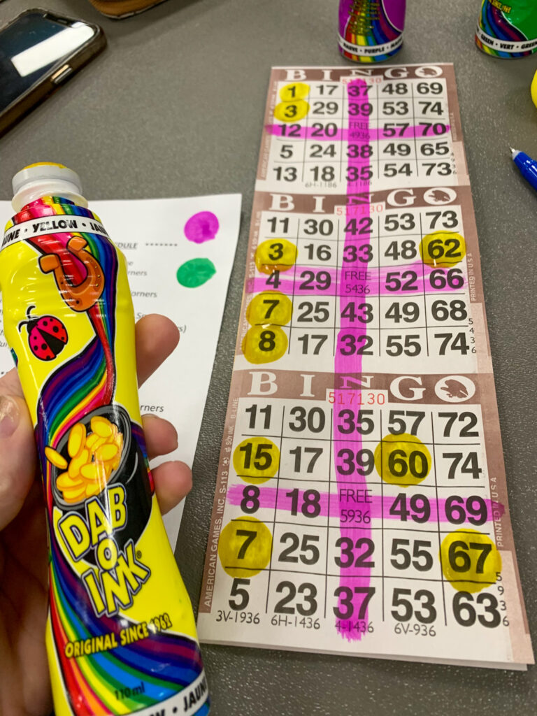 lady shows marked Bingo cards, Bingo dauber for fun Bingo night of funny Bingo puns and Bingo jokes