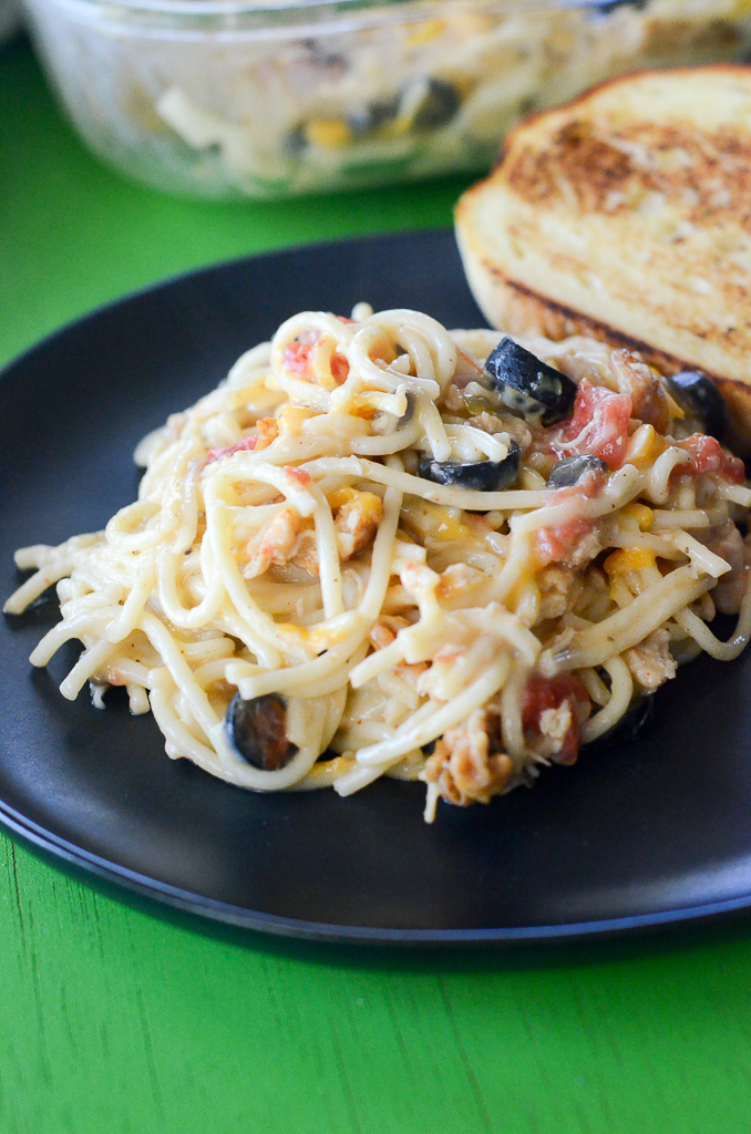 cheesy chicken spaghetti with Rotel and Velveeta on black plate with toast