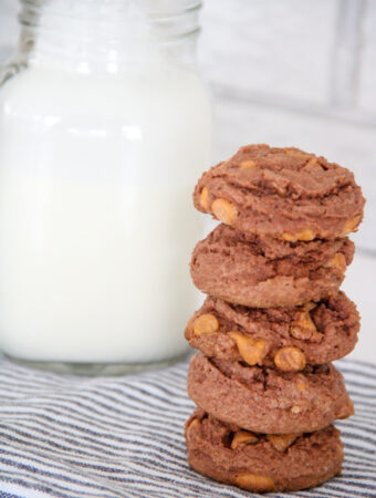 stacked butterscotch chocolate pudding cookies beside glass jug of milk