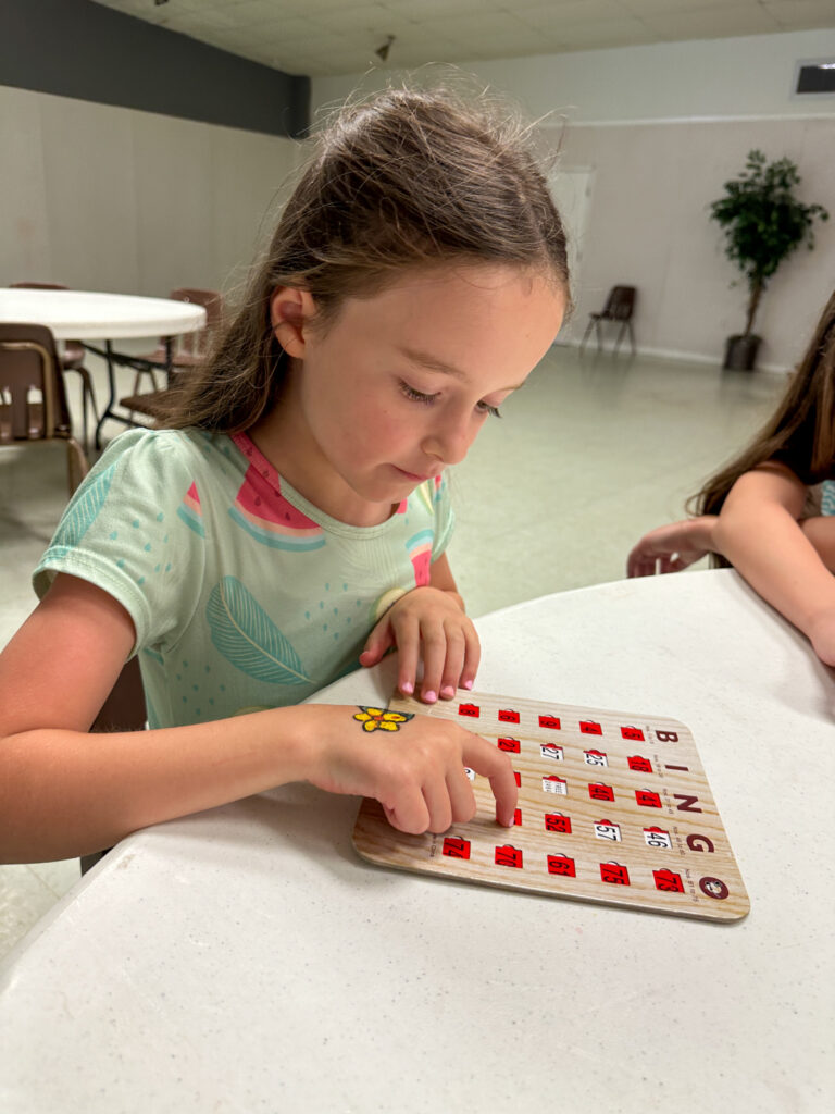 little girl playing Bingo games at a company picnic for inside picnic games