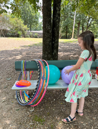 little girl picks out something to play with for company picnic ideas