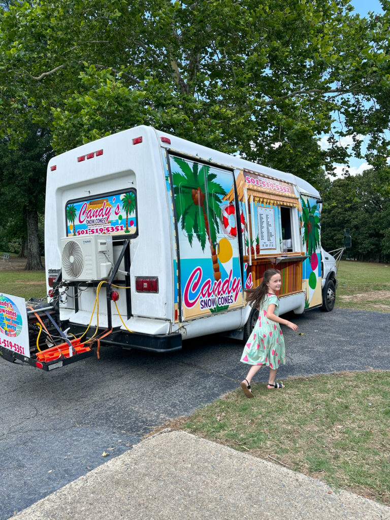 little girl in front of Candy's Snow Cones truck at Sherwood Forest in Sherwood, Arkansas for company picnic ideas