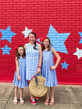mother and daughter July 4th outfits on mom and daughters in front of patriotic mural in Benton, Arkansas