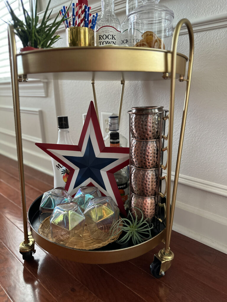 bottom shelf of a patriotic bar cart with July 4th decorations