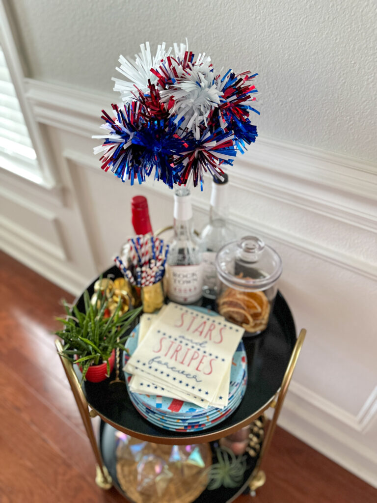 a top down view of a small round patriotic bar cart with red, white, and blue decor