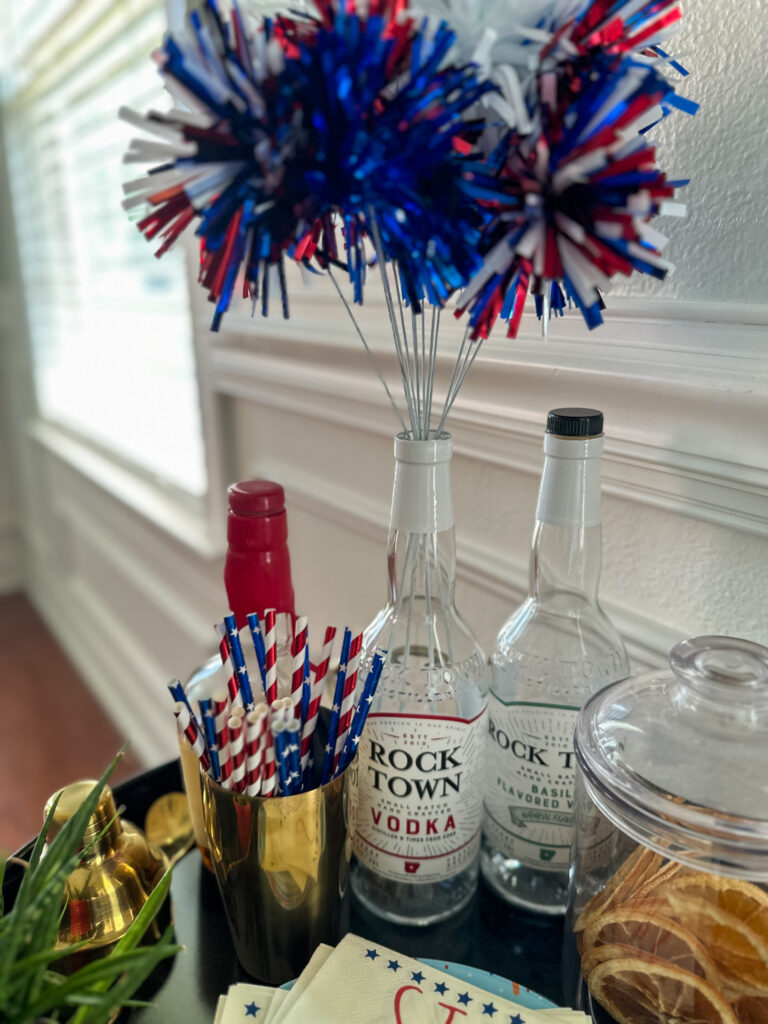 July 4th bar cart decorations with red, white, and blue picks coming up from a Rock Town Vodka bottle