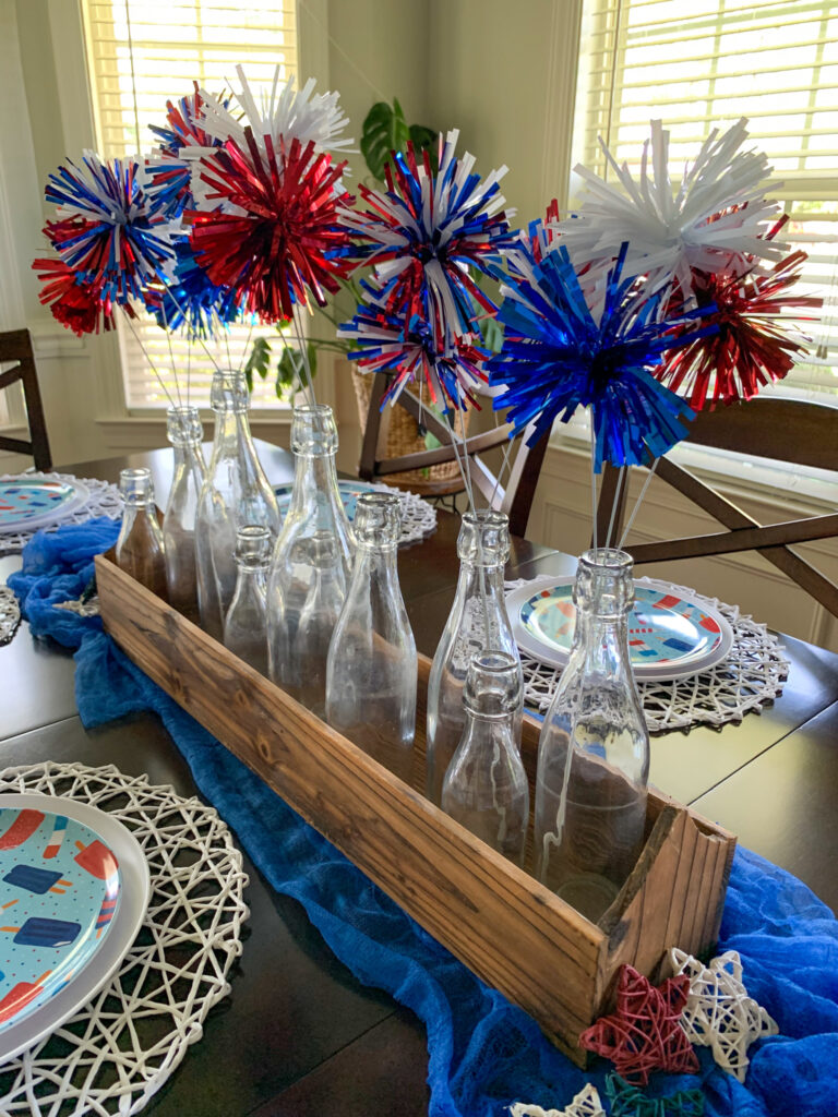 vases hold Fourth of July home decor picks in wooden tray on table