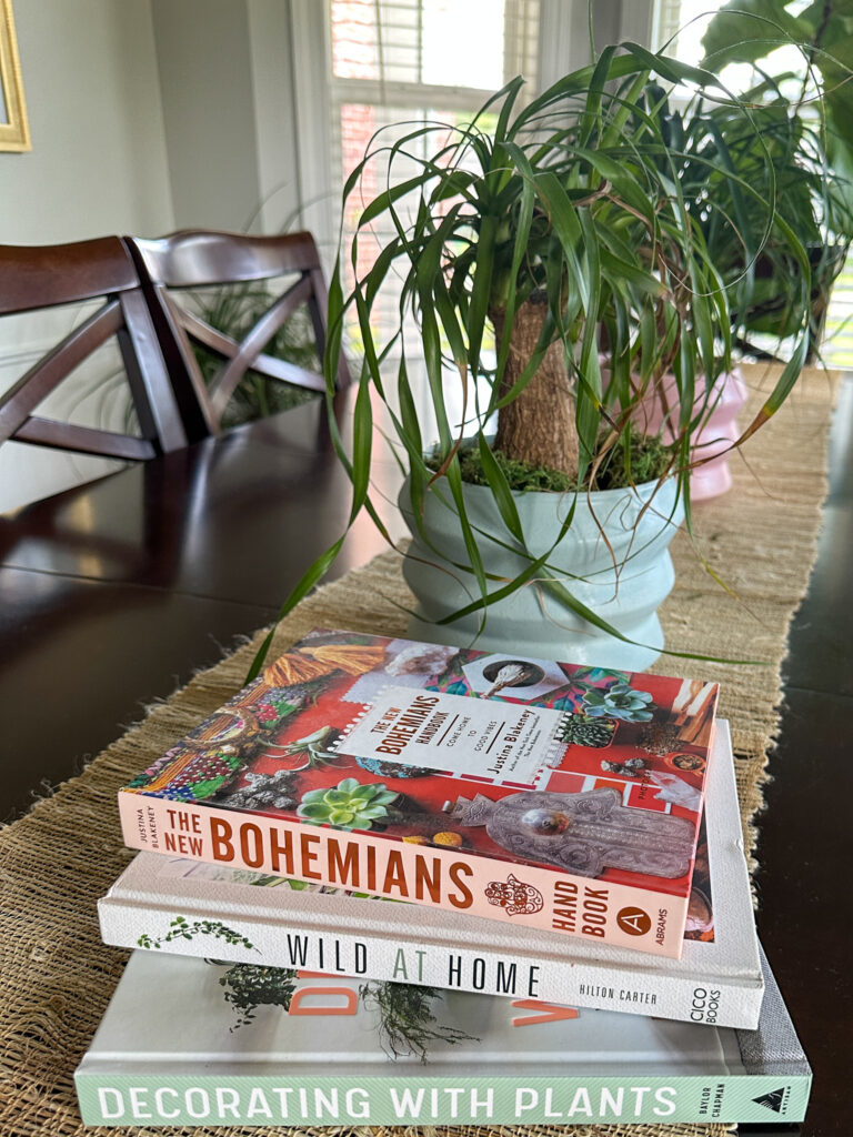 best plant books beside two ponytail palms on table