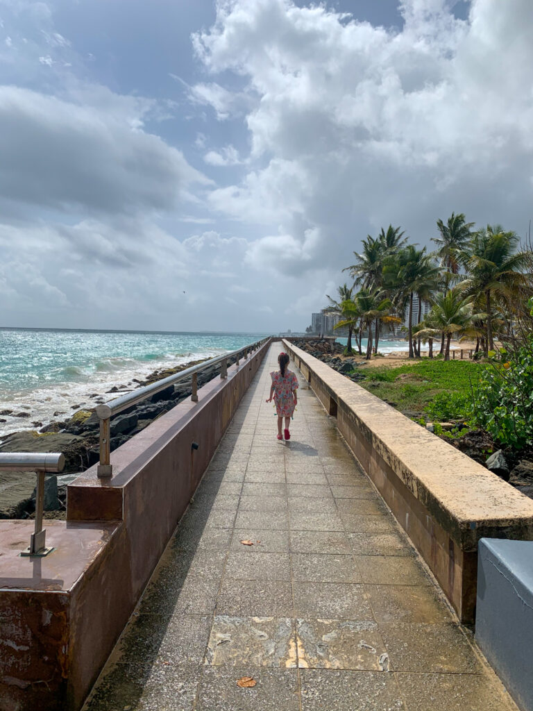 for ideas for kids at Condado Beach in San Juan Puerto Rico, a little girl explores the board walk 