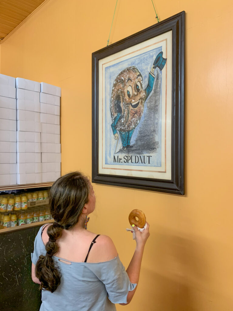 woman looks at framed vintage artwork inside The Spudnut Shop in El Dorado, Arkansas