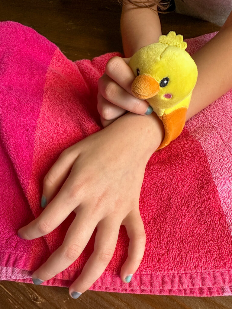 little girl with a cruising duck slap bracelet on wrist