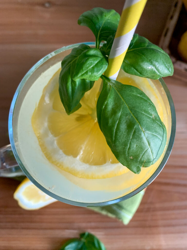 overhead shot of basil vodka cocktail with fresh lemons and basil on top